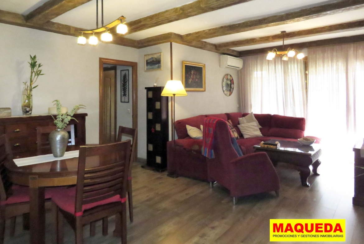 Salón comedor con suelos y vigas de madera