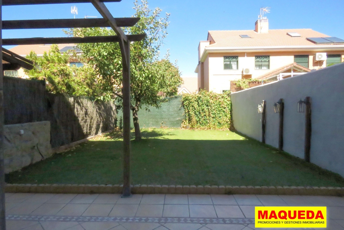 Jardín con pérgola de madera y césped artificial