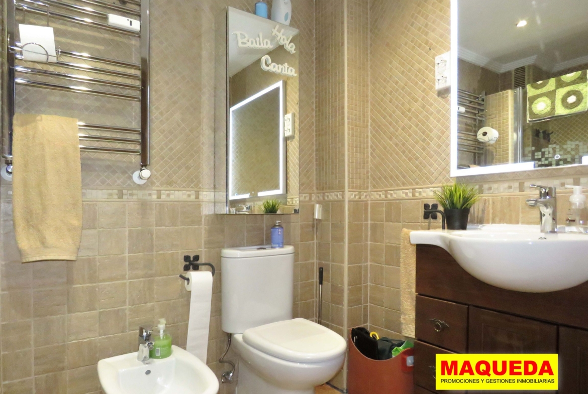 Baño completo con mueble bajo lavabo en madera oscura