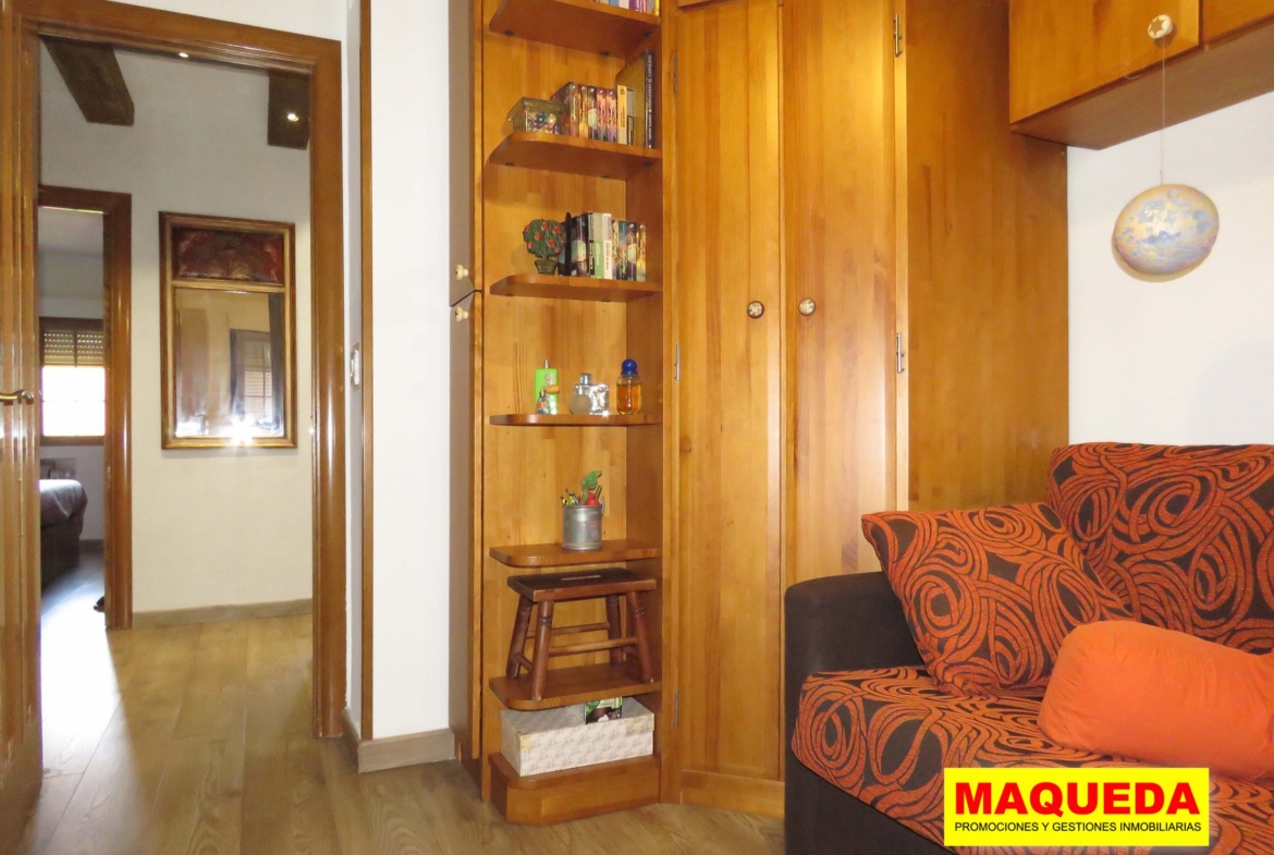 Habitación con mueble estantería de madera y sofá