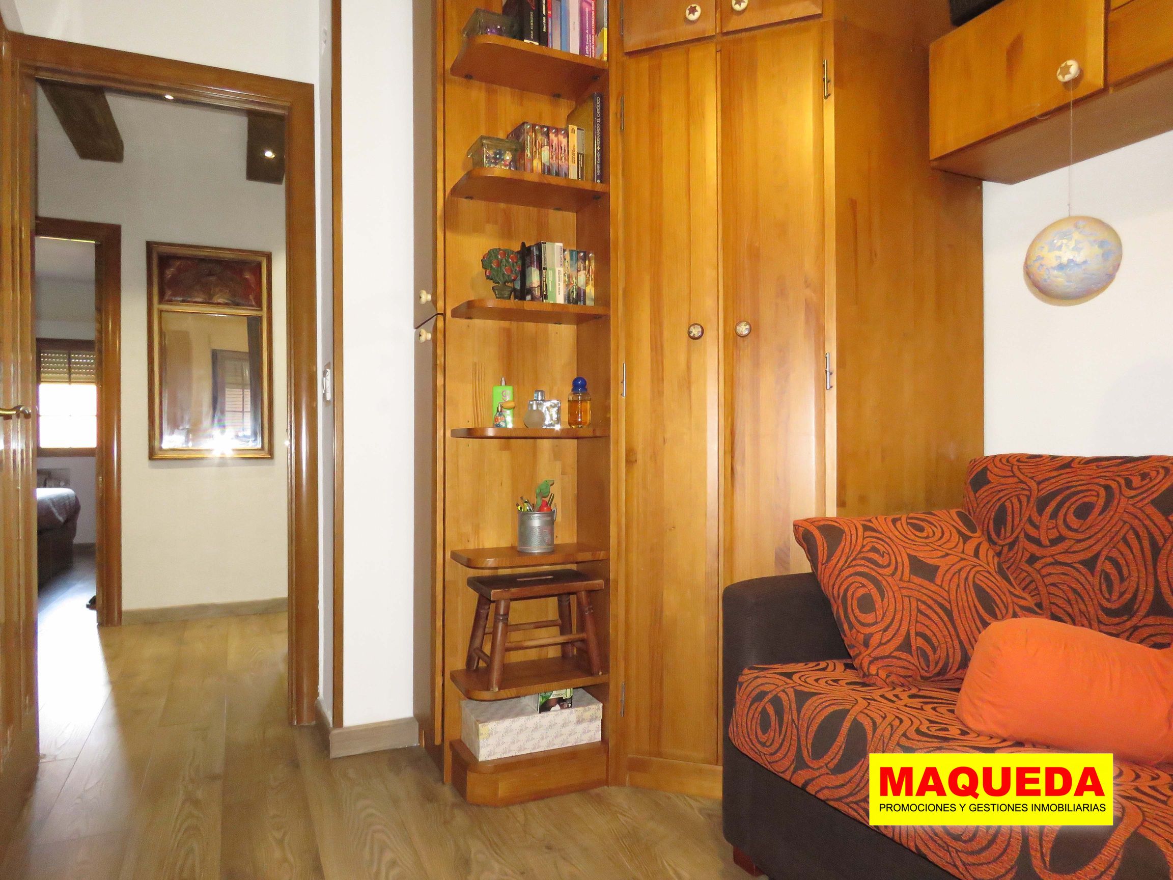 Habitación con mueble estantería de madera y sofá