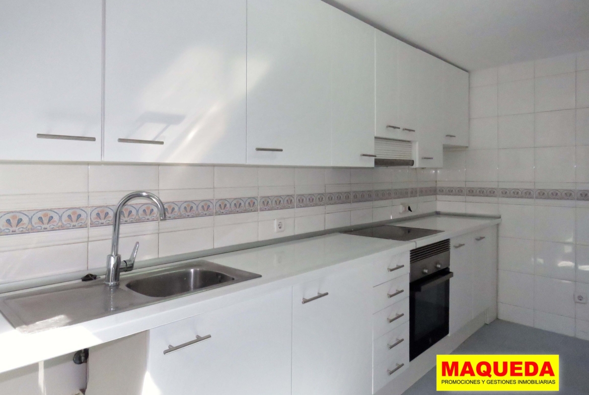 Cocina con frontal de muebles en blanco, horno y vitrocerámica