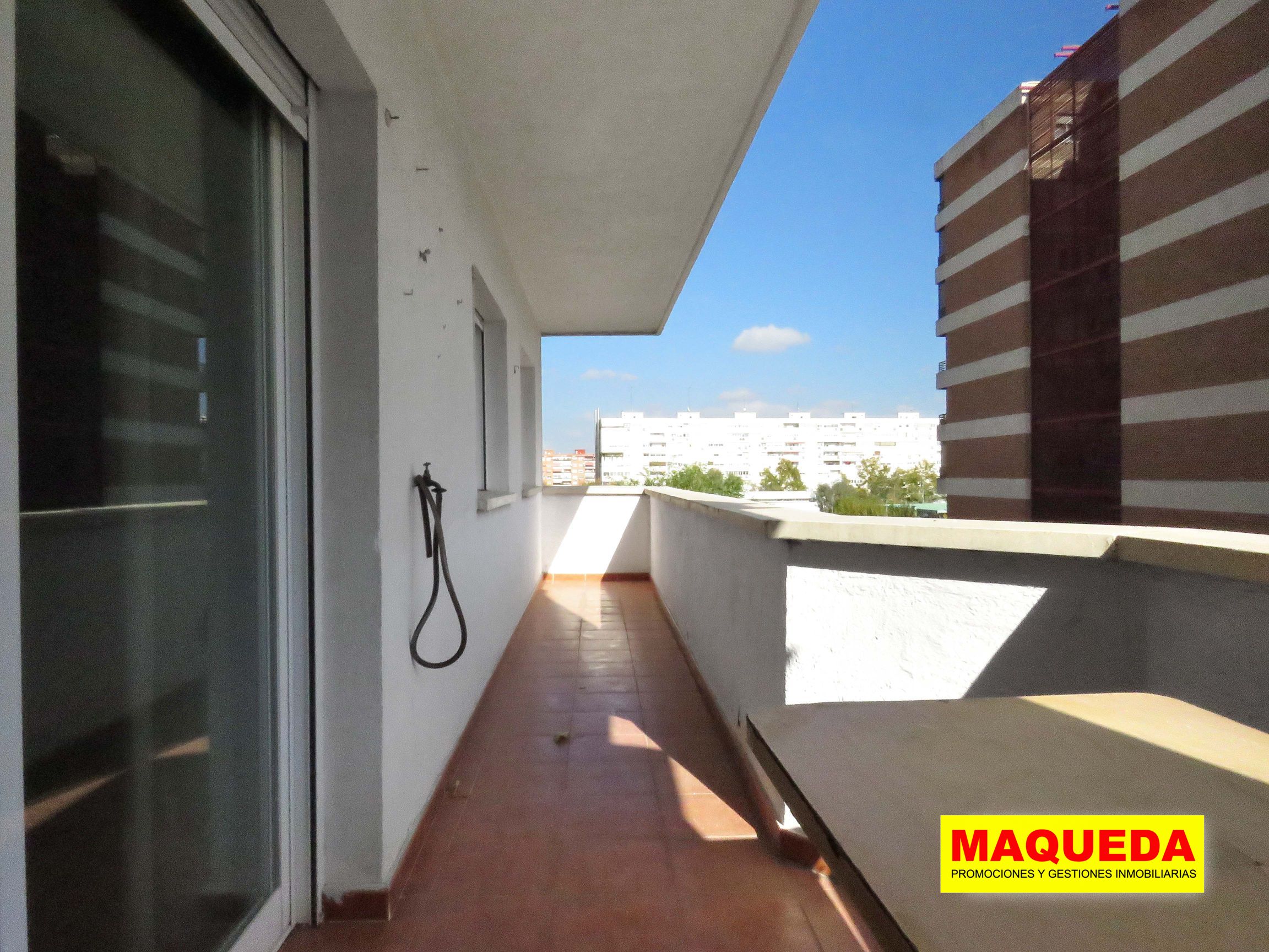 Terraza abierta con una parte más ancha al inicio y otra más alargada al fondo. A la derecha edificio alto de viviendas