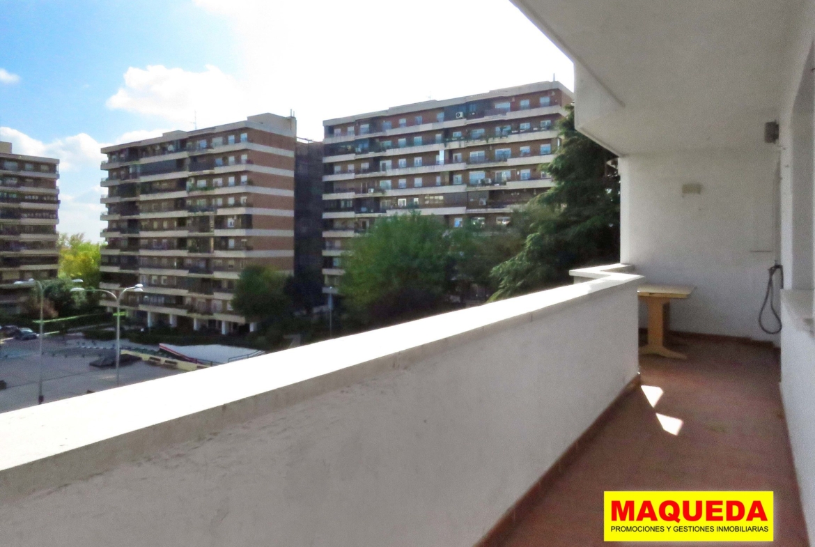 Terraza abierta con zona amplia para mesa y sillas al fondo. A la izquierda plaza de Residencial Igueldo con edificios de viviendas