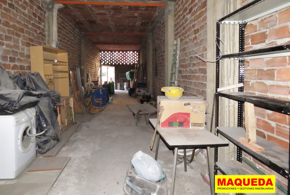 Interior del local en bruto en la calle Cañada de Alcorcón, con puerta de acceso al fondo